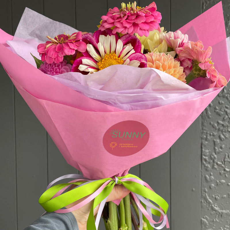 Seasonal flower bunch wrapped in pink paper with Sunny Flowers sticker, Havelock North